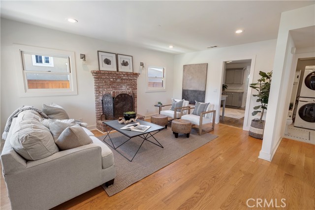 Living Room and one of two cozy fireplaces in the home.Wood burning and gas light. Beautiful hardwood floors and first floor laundry in the 1/2 bathroom.