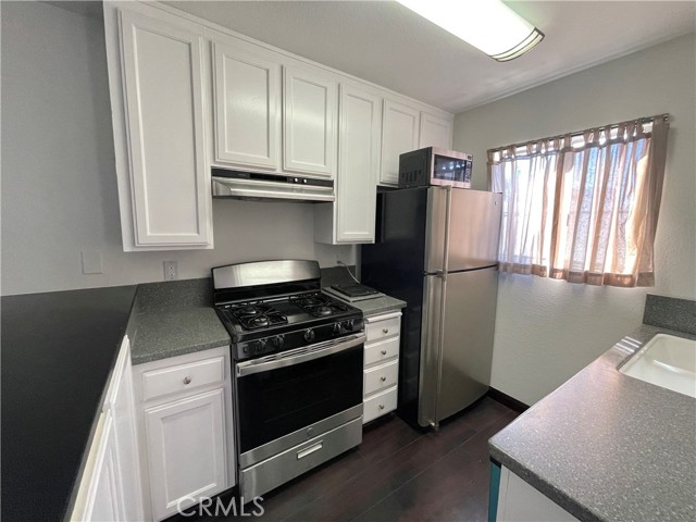 This compact kitchen provides beautiful dark hardwood floors, a new Stove, new Garbage Disposal, a dishwasher, a fridge, microwave and plenty of storage space!