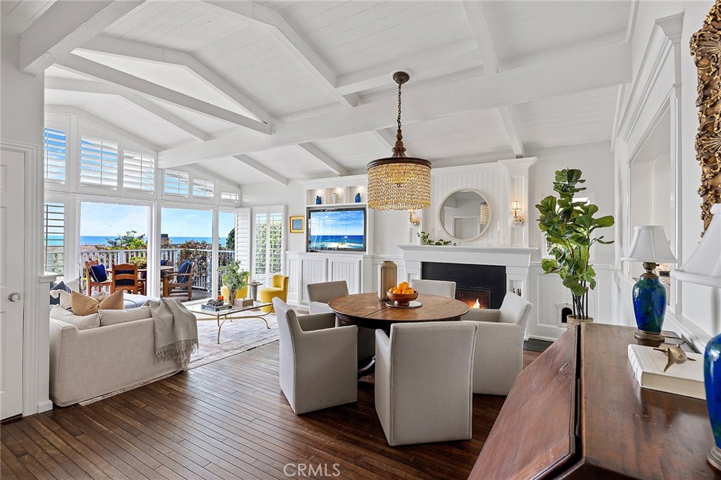 STUNNING COASTAL COTTAGE WITH PANORAMIC OCEAN VIEWS IN LOWER THREE ARCH BAY | Capturing the essence of timeless cottage charm, this beautifully remodeled residence showcases sweeping ocean and Catalina vistas and an unparalleled coastal lifestyle. Thoughtfully refined to preserve its classic allure while integrating modern upgrades, this turnkey beach house is a true gem. A welcoming Dutch door opens to a bright and airy interior graced with vaulted wood-beamed ceilings, custom cabinetry and millwork, rich hardwood floors and crisp white finishes throughout. The open-concept living room, enhanced by a warm wood-burning fireplace, effortlessly flows to the ocean-facing Ipe deck—perfect for enjoying refreshing sea breezes and mesmerizing sunsets. The chef’s kitchen is a culinary dream and features a La Cornue gas range, Sub-Zero refrigeration, marble top center island and walk-in pantry. Adjacent to the kitchen is the versatile sunroom showcasing a tiled gas fireplace, motorized louvered pergola, wall heaters, custom Murphy bed and a hidden laundry station. The inviting ambiance is ideal as a guest room, lounge, or for alfresco dining under the stars. A separate family room/study boasts custom cabinetry, built-in desk and dual workstations, creating a flexible and functional retreat. Two main-level bedrooms include built-in storage spaces and share a charming Jack-and-Jill bath highlighting a clawfoot soaking tub/shower and separate pedestal sinks. A powder bath with walk-in shower provides added convenience for guests. Ascend to the upper level to the private primary suite—a serene escape with views of Catalina Island, a sumptuous bath, and an expansive custom walk-in closet. Bi-fold glass doors reveal an inviting ocean-view balcony—an idyllic setting for morning coffee or sunset reflections. A luxe stainless steel spa by Diamond beckons you to relax in the private and lush backyard, complete with an outdoor shower. Additional upgrades include a Tesla Solar Shingled Roof (owned) and 240V level 2 EV charging outlet. Residents of Three Arch Bay enjoy private beach access, exclusive HOA amenities, and an active calendar of fun community and holiday events in this guard-gated enclave. Don't miss this opportunity to reside in one of SoCal's most sought-after seaside locations.