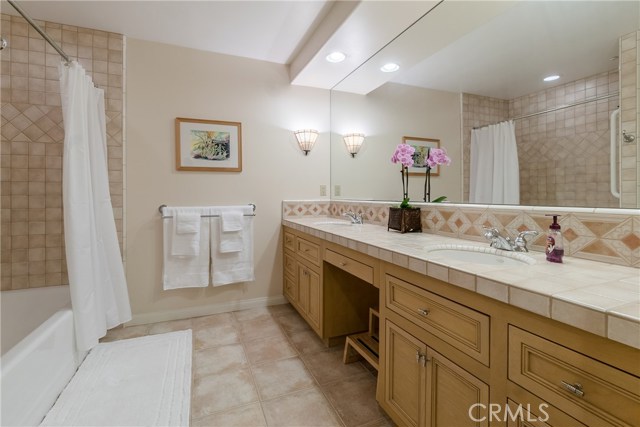 The adjacent full bathroom includes two sinks.