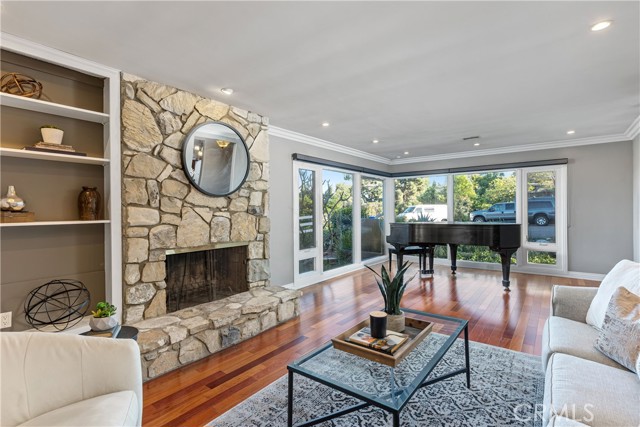 The formal living room with tall picture windows that overlook the surroundings bring in abundant natural light.