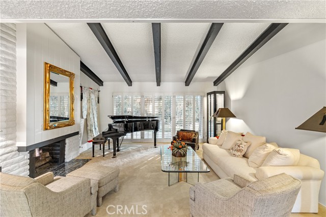 A perfect formal living room setting with tall ceiling and opening to the tranquil and beautifully landscaped backyard.