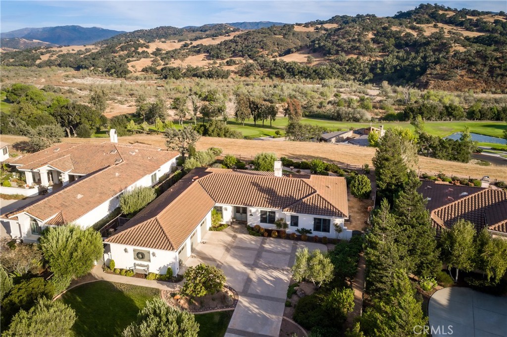 220 Valhalla Drive Solvang, California A rare perimeter lot in Solvang's coveted Village Collection neighborhood, with unobstructed vistas of the Santa Ynez River basin, the Alisal hills, and beautiful views of wildlife. This executive home was designed to take advantage of abundant natural light and views from almost every room. The custom build includes an open-concept kitchen and dining area; solid walnut wood flooring; two en suite bedrooms, a TV or entertainment room; dedicated office; and oversized living room w/grand fireplace bordered by display bays with accent lighting. The kitchen has a huge granite island; pantry; panel-ready refrigerator and freezer, and two refrigerator drawers in the island; a wet bar; double oven and professional range w/pot-filler tap. The primary bedroom features an immense walk-in closet and expansive bathroom with separate shower and soaking tub. Personal touches abound, including custom Santa Barbara ironwork hardware and light fixtures, mission-style wood front doors, designer window coverings, and vintage clerestory windows over interior double doors. The garage has 3 bays, extra storage, and a dedicated laundry room. The lot is a manageable yet spacious 17,242 square feet; the back yard has a covered patio area and meandering paths through the yard. Close to wine country and two golf courses: The River Course at Alisal and the Alisal Ranch Course. Wonderful for a primary residence or weekend retreat, enjoy the luxurious yet rural feel of the Central Coast.