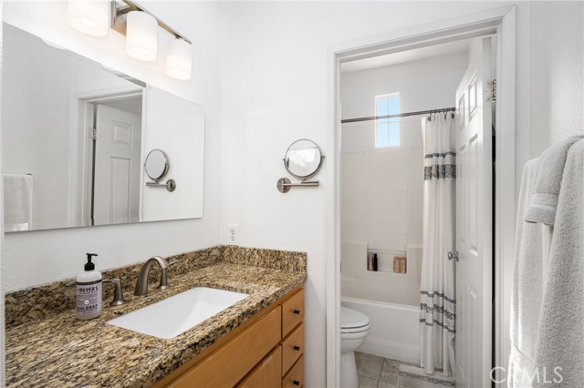 Master Bath with granite counters, porcelain tile floors and soft close custom cabinets an dshower/tub.