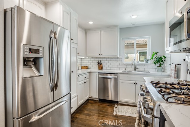 Looking into kitchen note marble counters and wall tiles & all Stainless appliances.