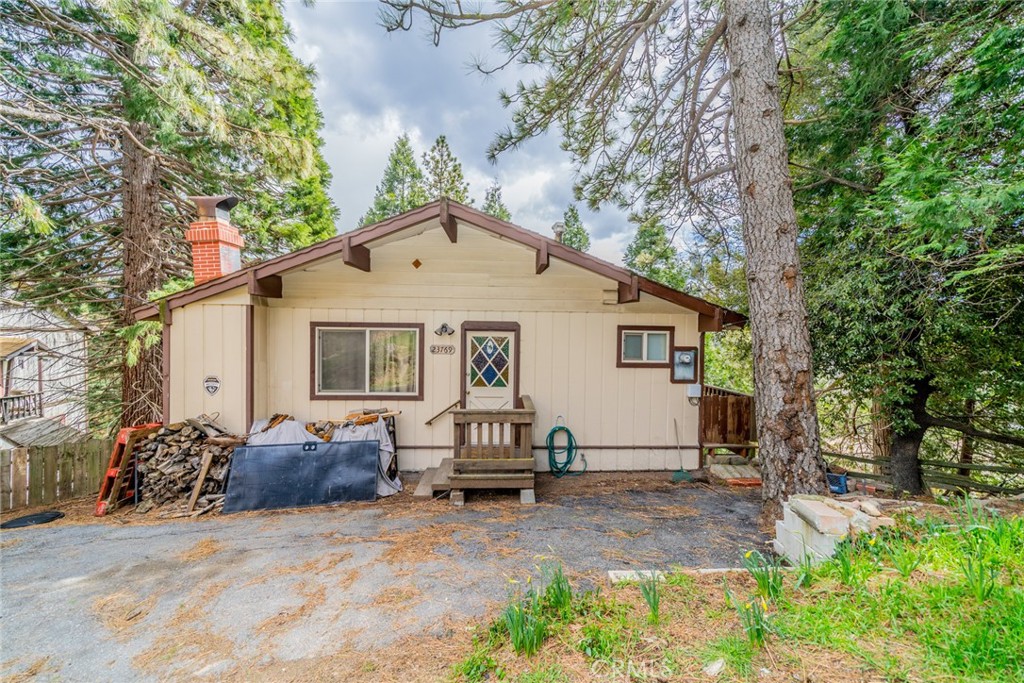 PRICED TO SELL!!!   BUYERS DELIGHT !!! LET'S OPEN ESCROW!!! Embrace the rustic charm of this wood-paneled cottage-style home in the mountains of Crestline and near Lake Gregory. The home welcomes you with wood vaulted ceilings accented with beams, a stone fireplace that will have you looking forward to colder evenings with lots of windows to let in the light and view the picturesque surroundings. Upstairs is the living room with newer wood-look flooring which also extends into the cute country kitchen, which has plenty of cabinet and counter space. The stove, refrigerator, and microwave are included. There is also a half bath which has recently been upgraded with a new vanity and sink. The wrap-around porch is great for entertaining or just enjoying the view with your morning coffee. Downstairs are 2 bedrooms, a full bath, with a tub and shower combo, and a large utility closet with a laundry area that can be used for more closet/storage space. There is also space to park two vehicles in front. This home will make you feel like your world’s away from the hustle and bustle of city life. Call and make an appointment today! Don’t miss this amazing opportunity where you can enjoy the great outdoors right outside your doorstep! The property is being sold as is in its current condition.