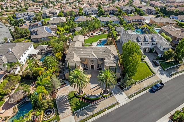 Rare opportunity to make one of the largest flat lots in Kerrigan Ranch your own, offering ultimate privacy with sprawling city light, hillside, ocean, Disneyland Fireworks, & sunset views. Curb appeal with one of only two circular driveways in the entire community, dual large palm trees, dual two car garages & dual stair cases. This grand 5 bed 5 bath entertainers dream estate offers downstairs office (not in bedroom count), upstairs oversized loft flanked by 3 kids rooms all with ensuite bathrooms & walk in closets, large custom movie theater, rock pool with slide, & master suite with breathtaking views from private balcony. Master suite offers two large walk in closets with custom built ins, bar area, soaker tub, dual shower head walk in shower, his & hers toilets, his & hers vanities, gym area, as well as second sitting area. Expansive great room offers a flood of natural light, fireplace, large kitchen with wolf & sub zero appliances, walk in pantry, & butlers pantry that leads to formal dining. Formal living room has fireplace & leads to dedicated wine bar with sub zero wine fridge. Largest backyard depth in the community offering large grassy area, rock pool with slide & waterfalls, fireplace, fire pit, covered outdoor kitchen, & koi pond. Please watch listing video & view 3D Matterport floorplan, thank you for viewing.