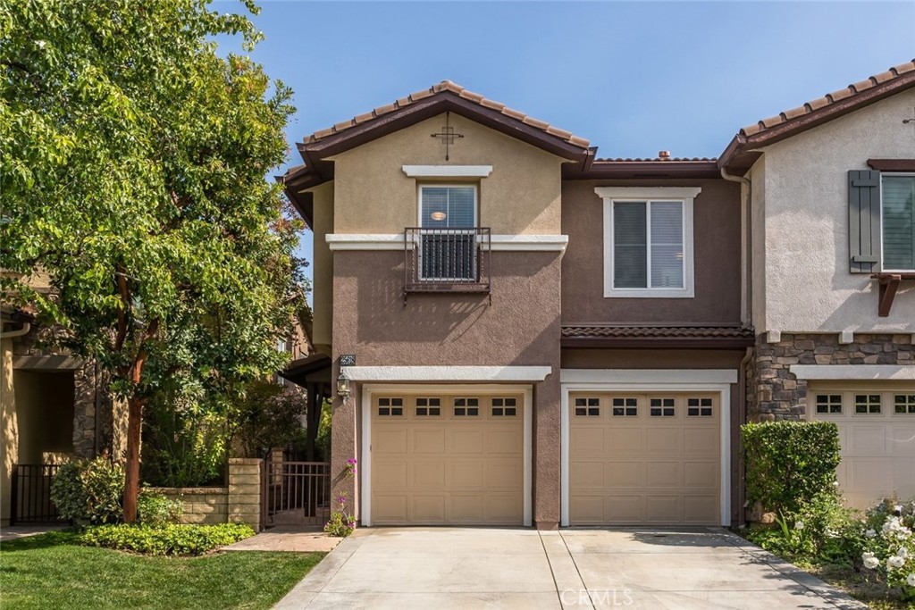 Welcome to this exquisitely upgraded townhome, nestled within the prestigious gated community of Bella Ventana in Westridge. Boasting nearly 2,000 square feet of refined living space, this stunning residence offers 3 bedrooms, 3 bathrooms, and a versatile loft, all situated on a peaceful cul-de-sac just moments from The Oaks at Valencia private golf course. Step inside to discover rich wood like flooring, tasteful designer finishes, and inviting paint selections. Oversized windows bathe the interior in natural light, while recessed LED lighting and sophisticated fixtures add an elevated ambiance throughout. The chef-inspired kitchen is a true showpiece, showcasing brand-new shaker cabinetry with soft-close functionality, sleek quartz countertops with a breakfast bar, and premium stainless steel appliances. The adjoining family room, complete with a cozy fireplace, opens to the serene backyard—perfect for relaxed gatherings. The spacious dining area is ideal for entertaining and enjoys views of the backyard as well. Upstairs, the luxurious primary suite offers a private retreat with a spa-like en-suite bath featuring custom stone wall tile, an oversized double vanity with quartz counters, a walk-in shower, and a freestanding soaking tub. You will love the huge walk in closet and access to a private balcony for enjoying warm summer evenings. The additional bedrooms are generously sized and thoughtfully finished with designer lighting and ample closet space. A beautifully renovated hall bath features a double vanity with quartz counters and an abundance of storage and a custom tiled tub/shower combo. The expansive loft offers endless possibilities—ideal as a library, office, or additional lounge space—with its own access to the upper balcony. Outdoors, enjoy a low-maintenance yard with a charming patio area perfect for entertaining. Additional highlights include an attached two-car garage, an upstairs laundry room, and abundant storage throughout. Residents of Bella Ventana and Westridge enjoy access to resort-style amenities including pools, spas, a clubhouse, tennis courts, sport courts, parks, and lush common areas—all within close proximity to award-winning schools, shopping, and convenient freeway access.