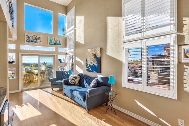 The living room features approximately 20ft ceilings, sliding glass door and a panoramic ocean view.