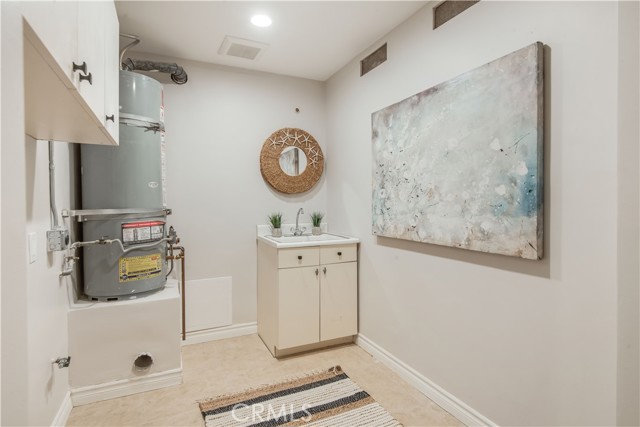 Separate laundry room with sink, cabinets, on main floor.