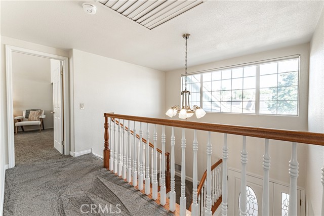 Top of the stairs with window that has shade with remote