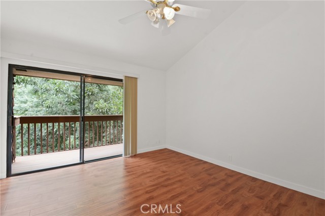 Upstairs back bedroom with relaxing balcony with peaceful tree views, walk-in closet and newly installed laminate flooring.