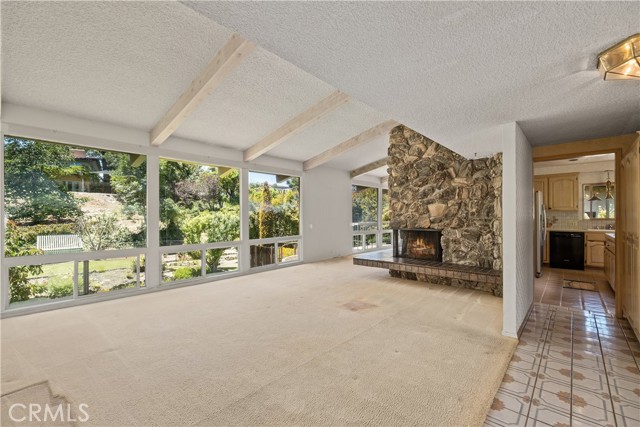 Main living room looks out over back yard, fire place, leads to dining room.