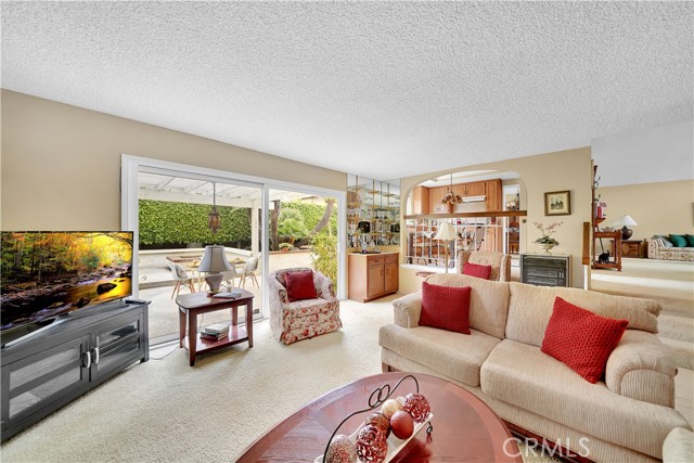 Inviting Family Room Located Right Off the Kitchane that Includes Crackling Fireplace, Wet Bar, and Sliders that Open to a Lovely Tranquil Very Private Backyard with 2 Patio Areas