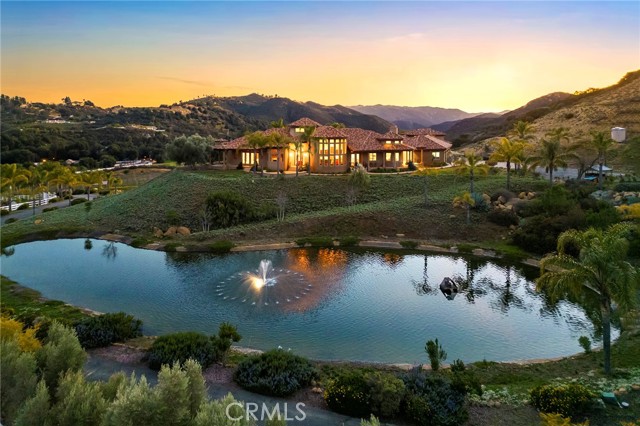 Don't miss out on this extraordinary opportunity to own an exceptional estate! This stunning 38.6-acre property boasts elegance, craftsmanship and breathtaking panoramic views. With its natural beauty & equestrian charm, this idyllic estate is a rare find!

Featuring  700 producing grapevines, a barn with 9 horse stalls and additional pens for small farm animals, a private lake, pool & spa, this property is a sanctuary of tranquility. With no HOA fees, two wells, and fully paid-off solar panels, it offers both self-sufficiency and sustainability.

The main residence is 4486 square feet and includes a gourmet kitchen with a custom wine refrigerator, 3 ovens, and a warming drawer. Three bedrooms, an office, an expansive laundry room, and a luxurious master bath complete with a circular spa tub, walk-in shower, and dual vanity sinks. Additionally, a separate 2-bedroom, 2-bath house with an attic, built in 2015 and comprising 1064 square feet, provides additional living quarters.

The property also features a private shooting range & RV pad and hookups!