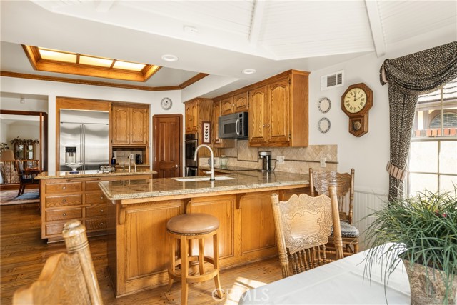 Spacious Kitchen with Granite Island and Sunlit Breakfast Area