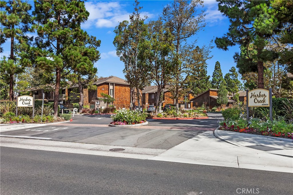 Well located and desirable controlled access Harbor Creek community within a convenient distance to the sand at Doheny State Beach/Park and Dana Point Harbor.  Well maintained community and pristine landscaping.  Quiet end unit with the sounds of running streams and soothing ponds encompass this very private upper unit with high ceilings.  Gentle ocean breezes and views of the streams from the outside deck. You can fall asleep from the sounds of the streams outside your bedroom window.   All new rich warm cabinets in the bathroom and kitchen. Both feature granite counters and all new fixtures & lighting.  New LCD recessed lighting in kitchen, new electric range, microwave, garbage disposal, newer dishwasher and includes new refrigerator.  There are 3 ceiling fans, a walk in closet and new air conditioning unit.  Outside on the deck find the laundry closet that fits a full size capacity washer & dryer.  Your carport is located a convenient distance at the rear of development, Space #223.  Just behind Harbor Creek is a gate off of the parking area to Sycamore Creek Park and trail. There is a children's play area and terrific trails that will take you to the beach in a few minutes. The HOA covers the water (including hot), trash, sewer & gas.  Located off the gated pool & spa is a community laundry & sauna.