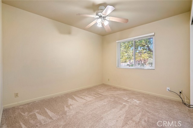 Bedroom features plush carpet, ceiling fan and views to the front yard.