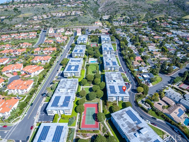 Aerial view of complex shows both tennis courts and one of the pools. Red pin shows location of building in which property is located.