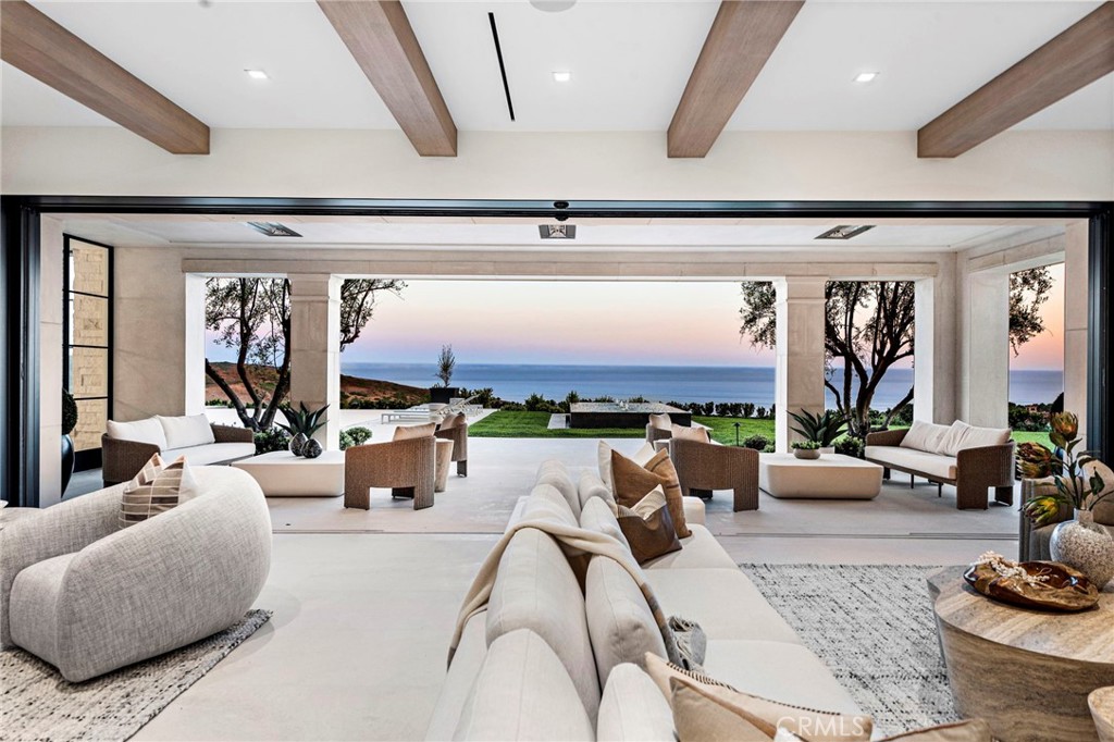 Perched at the pinnacle of Crystal Cove, this newly constructed estate embodies the pursuit of perfection and privacy. Beyond secure gates on over a 3/4 acre of land, the home’s coastal positioning unveils sweeping 270-degree ocean views and priceless peace. Spanning 18,336 sq. ft. +/- with 6 bedroom-suites and 12 bathrooms, this residence boasts luxurious accommodations and sun-drenched living spaces. The two-story entry foyer showcases a bold glass orb chandelier, embraced by a three-story floating staircase, which highlights the vast scale of the home. The awe-inspiring great room pulls visitors in with walls of glass that vanish from sight at the touch of a button, replaced by unfathomable views of endless ocean that infuse the space with a profound sense of ease. Allied with the great room, the primary kitchen is a sleek and modern central space, where paneled glass walls are used to deftly link to a California room. Natural light shines on brushed limestone floors, rift-cut oak cabinets, and thick slabs of Calacatta Oro Supreme marble on a centerpiece island with bar seating. Appliances are top-line with Wolf 6+ burner range, double ovens, Subzero paneled refrigerators, and Miele dishwashers, and an adjoining private catering kitchen is equally well-equipped. The main level is completed by two stylish guest bathrooms and a junior primary suite with ocean views, walk-in closet, and a large ensuite bathroom with soaking tub and steam shower. The upper level hosts a collection of bedrooms anchored by the primary suite with a balcony that looks out on ocean swells, lavish dual bathrooms, and dual custom walk-in closets. The lower level features a huge lounge area encircled by a home theater, wine bar with a temperature-controlled wine closet, gym/flex room with sauna, cold plunge, and steam shower, a large guest suite, a laundry care room, and a 10-car subterranean garage. The home features advanced technology, 7 HVAC units, on-grade parking in the secured entry motor court, and a commercial elevator servicing all three floors. Outdoor areas rival the vibes of a luxe resort hotel with meticulously landscaped grounds, an oversized swimming pool and spa, and an outdoor loggia and kitchen area that looks out over the stunning Pacific.  Crystal Cove has 24-hour guard-gated security and offers unmatched amenities: residents-only access to The Canyon Club, as well as direct access to Crystal Cove State Park, and proximity to upscale shopping and dining.