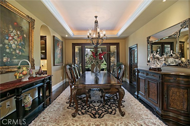 The Dining room is elegant with a wrought iron chandelier and French doors that open to the outdoor lanai.