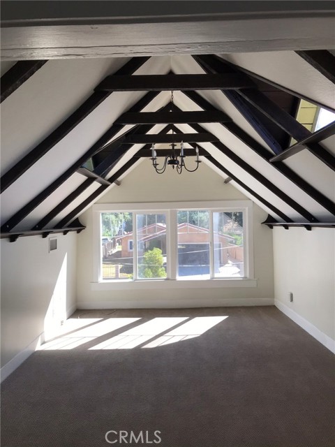 Front of unit with peaked and beamed ceilings.