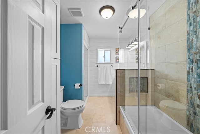 Hallway full bathroom - Remodeled in 2023: New shower and tub with travertine tile, additional storage added, new vanity and tasetful shiplap.