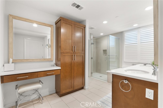 Primary bath with dual sink vanity, dressing area, linen/storage tower, soaking tub and stall shower.