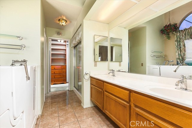 Primary bath with dual basins, walk in shower, walk in tub and walk in closet with built ins.