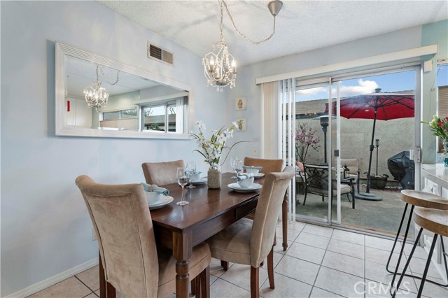 Dining area can accommodate up to six and has a pretty light fixture to add ambiance. Sliders to spacious patio set between the unit and large 2 car garage.