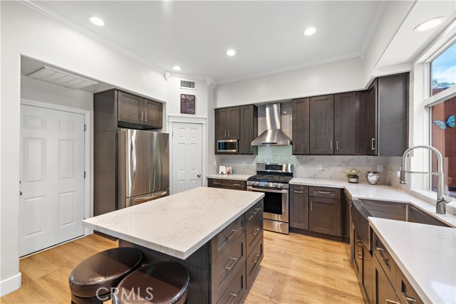 Now this is a KITCHEN! Recently remodeled with today's designer trends, it offers quartz counters, soft close cabinets and drawers, stainless appliances and stainless farm-style sink and a stainless hood.