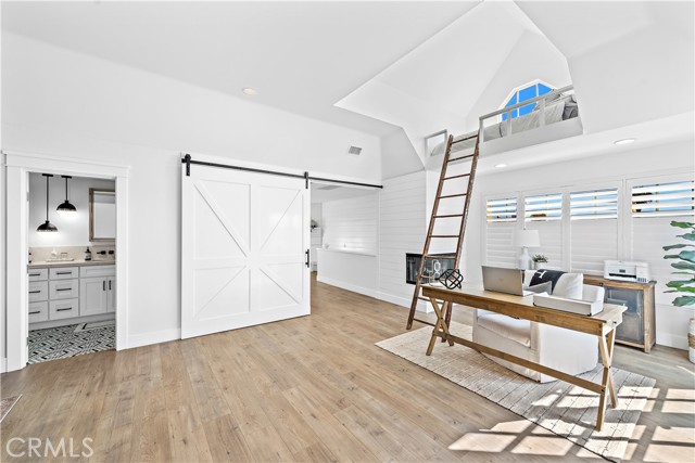 Upstairs family room features a large barn door that can be closed to create a large Primary Suite with dedicated office space and a dual sink bathroom.