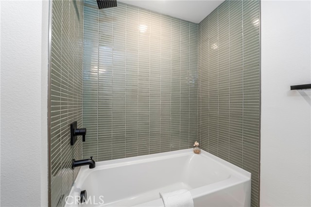  Guest bath with large vanity, soaking tub and shower with tile surround and solatube