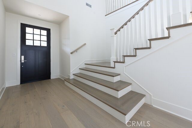 Front door and grand staircase tucked along the side of the entry way.