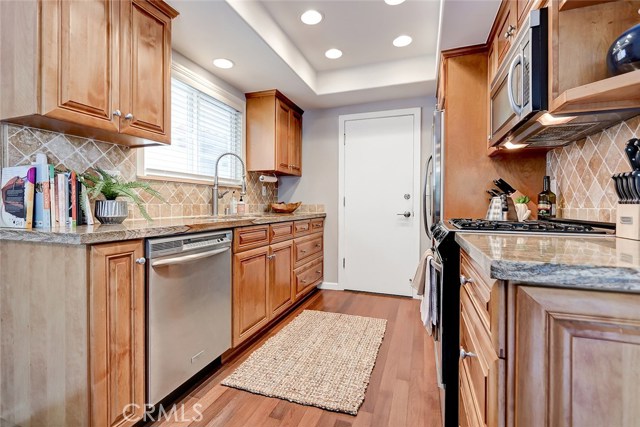 Kitchen includes granite countertops and tile backsplash.