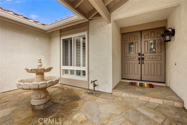Elegant Flagstone coupled with the soothing sounds of a water feature creates a pleasant and welcoming ambience.  Beautiful and custom solid wood, double-door entry with Schlage Keyless, wi-fi entry.