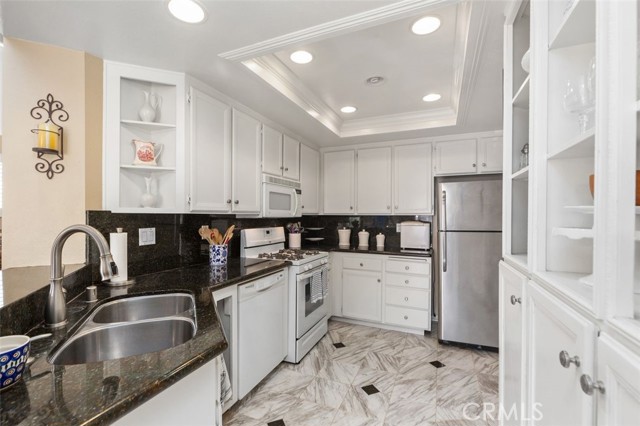 White kitchen with granite countertops.