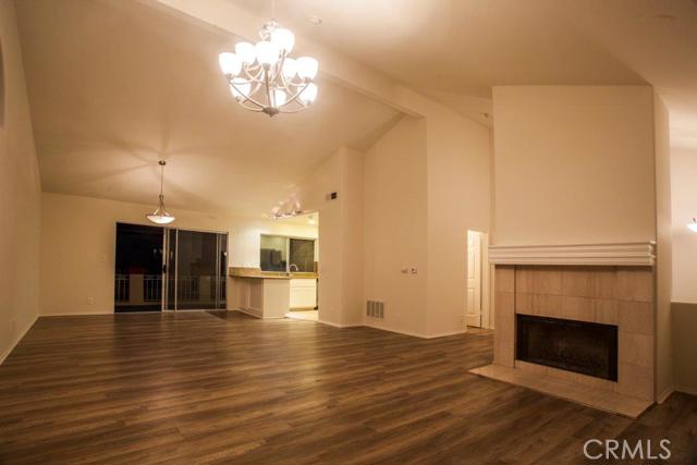Living room/great room with fireplace/gas starter, new flooring, new lighting, large balcony, ultra high ceilings.