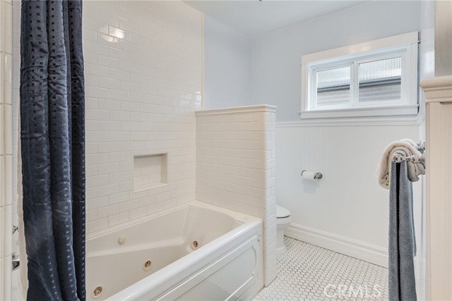 Hallway bath with beautiful wainscottting, white mosaic tile floor straight out of coastal living