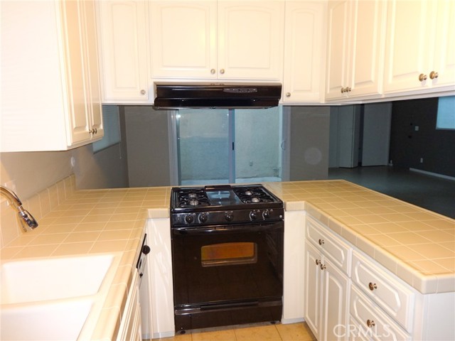 Looking down the length of the kitchen showing the break in the cabinets with counters to the dining area and family room