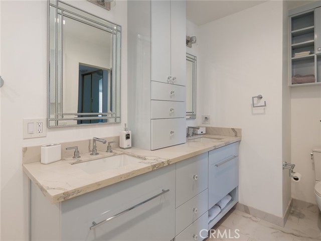 Elegant en suite primary bathroom with quartz counters - brighter in person, efficient storage, grab bars.