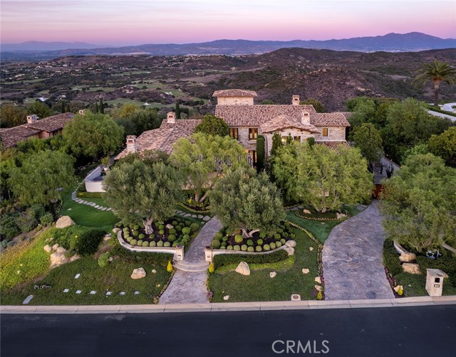 Perched atop a serene Shady Canyon hillside, this three-level estate redefines luxury living. From an elevator serving all floors to exquisite stonework to a stone-clad jacuzzi and infinity pool merging with the valley below, the home offers opulence at every turn. The gourmet chef’s kitchen boasts a Thermador suite of appliances including a refrigerator, double oven, and six-burner stovetop, stone farmhouse sink, wood-beamed ceilings, and well-appointed pantry. The living and family rooms offer spectacular stone fireplaces, and the latter includes a sunken wet bar for all your mixology needs. The main-level master suite features a coffered ceiling, stone fireplace, and spacious walk-in closet. On the top floor, you’ll find three bedrooms ( One bedroom has a tower room also) and a versatile bonus room, while the lower level showcases an inviting theatre room, bonus room (could be a additional bedroom), wine room, cedar-lined sauna, workout room, and sizable garage with a workshop area, abundant storage, and parking for six-plus cars. Additional highlights include solid wood interior doors, custom sliding doors, sleek marble and carpet flooring, state-of-the-art GE alarm system, outdoor fireplace, two gas bbq's, and more. This residence exudes sophistication, offering an exclusive sanctuary for discerning buyers. Don't miss this exceptional opportunity to embrace the ultimate luxury lifestyle.