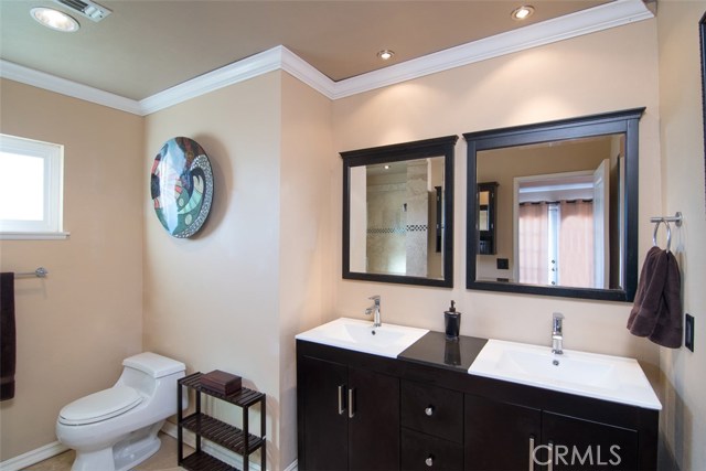 Master bedroom bath with newer vanity with double sinks and lush travertine flooring.