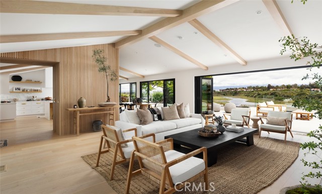1936 Galaxy Drive Newport Beach, California This architectural ranch-style gem in Dover Shores offers striking design, breathtaking Back Bay and city light views, and an abundance of outdoor space, including a private courtyard with a stunning pool and spa. Set on a 9,000 square foot lot, the 3,355 square foot home features 4 bedrooms and 4 bathrooms, welcoming you with a custom white oak entry, soaring beamed ceilings, and a seamless indoor-outdoor flow. The living and dining rooms showcase a white brick fireplace, serene vistas, and a custom built-in bar. Anchoring the home is a showpiece chef’s kitchen with Calacatta marble countertops, floating white oak shelving, designer brass hardware, and top-tier appliances. The expansive deck is an entertainer’s dream with a fire pit, dining area, and lounge space overlooking panoramic views. Major structural upgrades—including a massive grade beam and multiple caissons—make this one of the most soundly built homes in the area. The luxurious primary suite opens to the deck through folding glass doors and offers a spa-like bath with a freestanding tub, glass-enclosed shower, and polished Calacatta marble finishes. Three additional ensuite bedrooms and a versatile family room opening to the pool complete the layout. High-end details include white European oak floors, custom