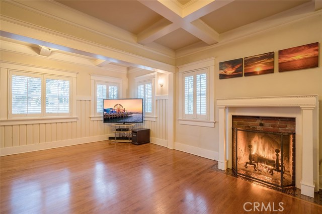 Living room looking to the front of home windows. The finished accented exposed wood beam ceilings set the room as an expansive space for family and friends.