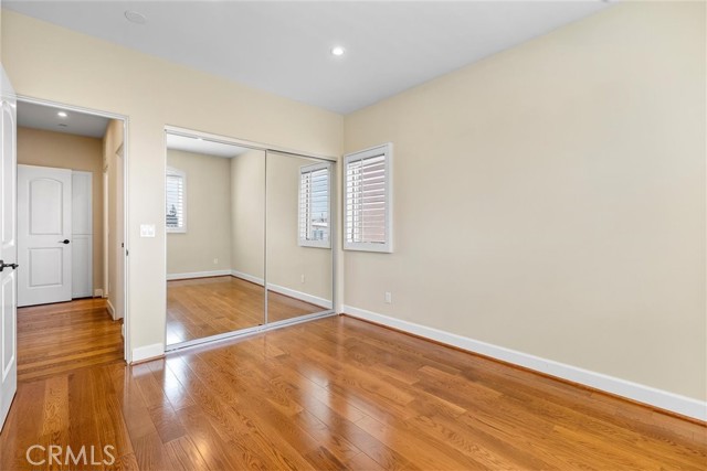 Top level extra bedroom with large closet and hardwood floors