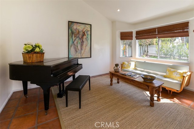 A photo of the living room showing the nice view of the yard and space enough for a baby grand piano!