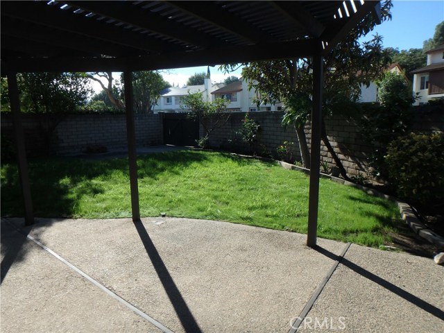 Patio with covered patio looking into the backyard.