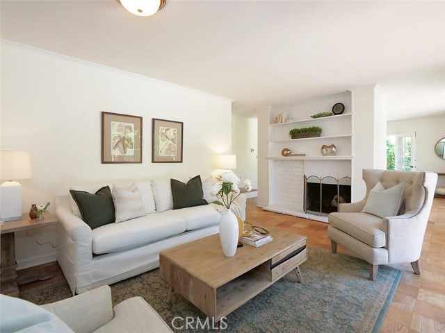 From the entry step into the comfortable freshly painted living room with beautiful wood floors, fireplace and French doors to your right outside the photo.