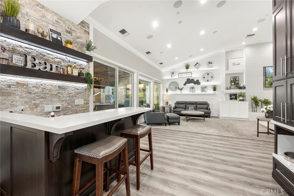 Bar has stone wall, shelves with accent lighting,Quartz counter, & lighted Dog Feeding Station
